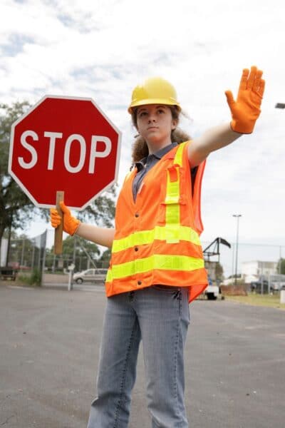 A female construction worker stopping traffic.