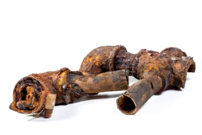 Fragments of old cast-iron water pipes on white background.